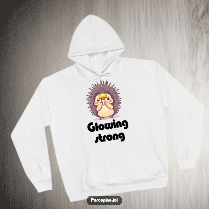 Funny hoodie depicting a porcupine holding a small, illuminated mushroom, perfect for cozy evenings filled with magic and humor.